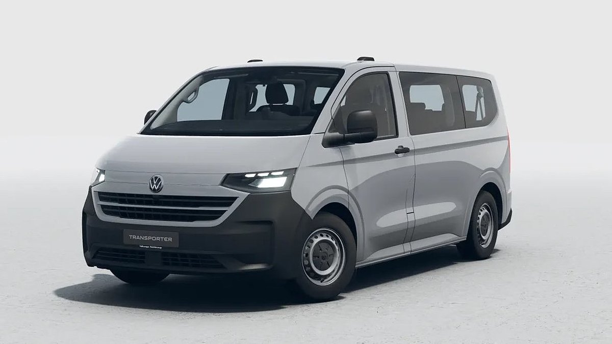 Grauer VW Transporter in schräger Frontansicht vor hellem Studiohintergrund.