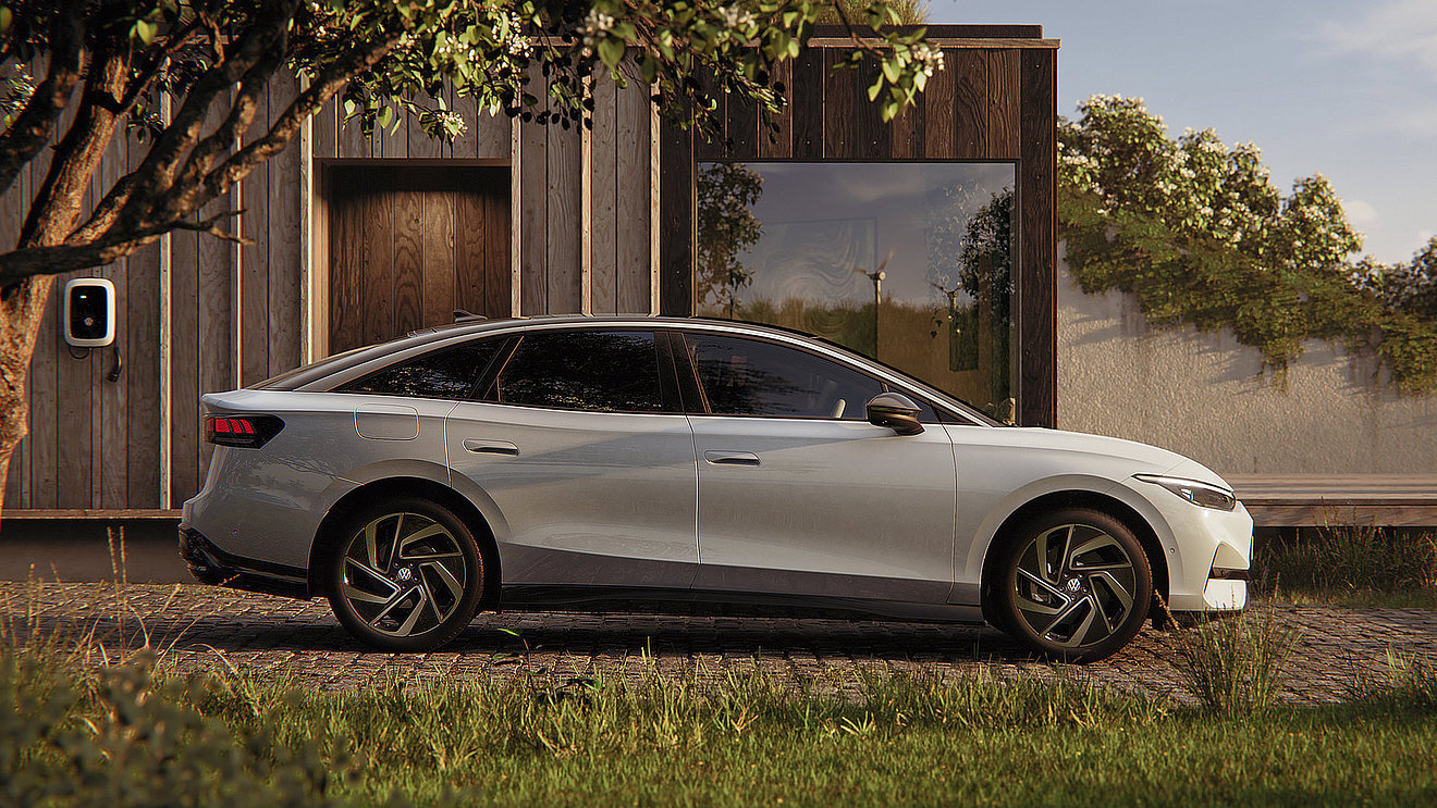 Silberner VW ID.7 als vollelektrische Limousine in Seitenansicht vor modernem Wohnhaus mit Wallbox – komfortables Elektroauto für Alltag und Langstrecke bei Autohaus Fischer in Thüringen.