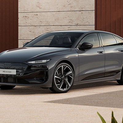 Audi A6 e-tron in Magnetgrau vor moderner Architektur