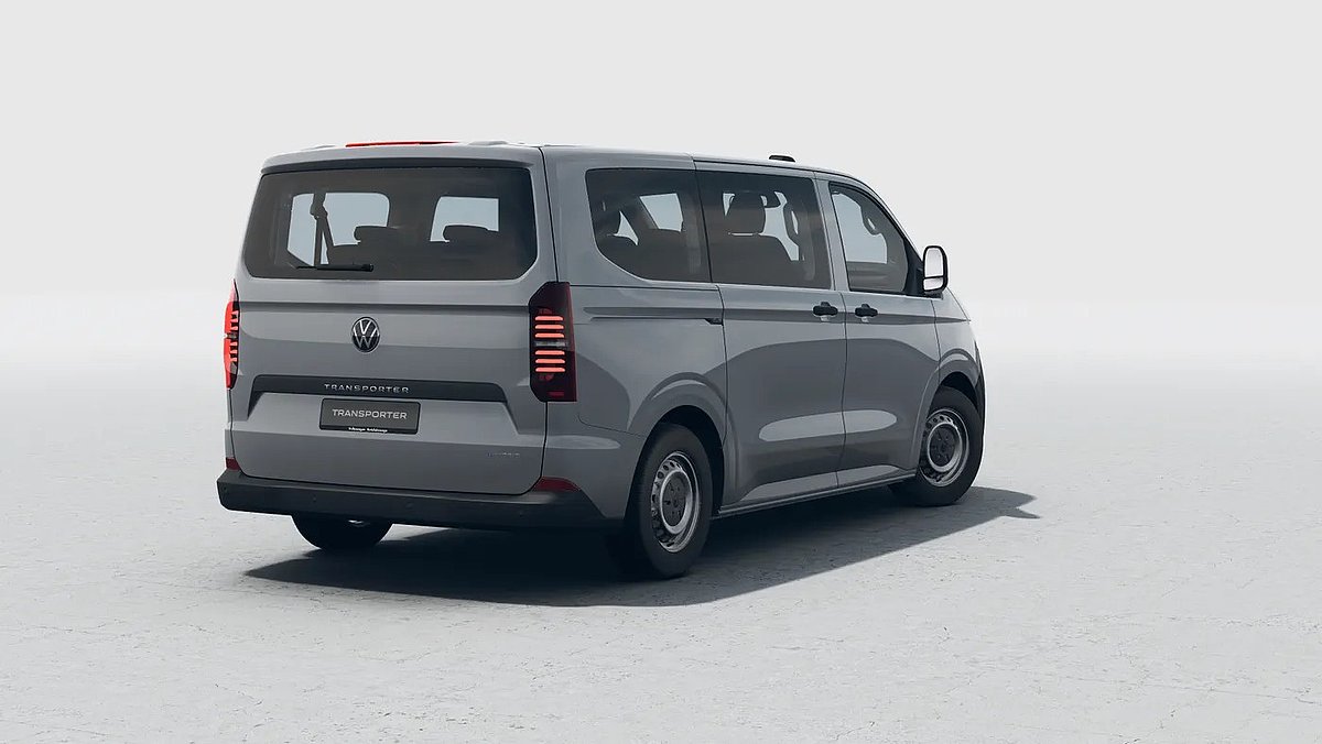 Grauer VW Transporter in der Heckansicht schräg von hinten auf hellem Untergrund.