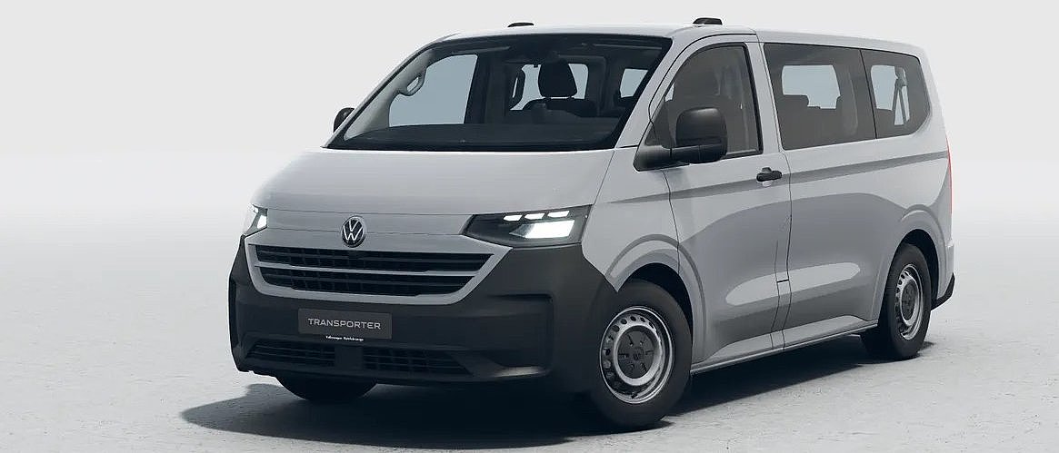 Grauer VW Transporter in schräger Frontansicht vor hellem Studiohintergrund.