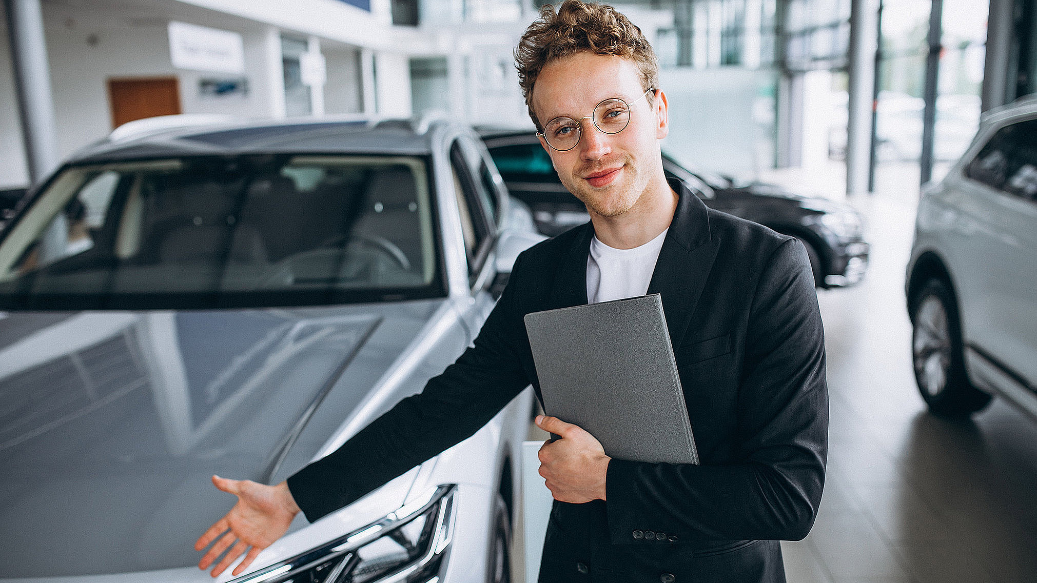 Automobilverkäufer im Autohaus präsentiert einen Gebrauchtwagen im Showroom in Bad Lobenstein.