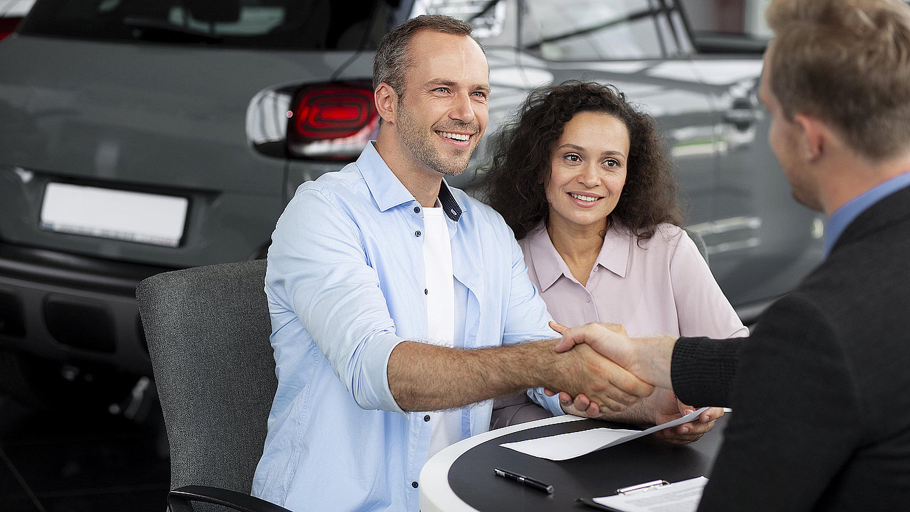 Beratungsgespräch im Autohaus mit Handschlag zur Vereinbarung einer Probefahrt bei Fischer Auto