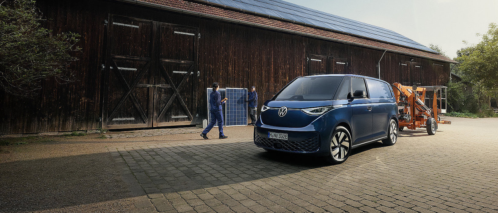 Volkswagen ID. Buzz Cargo auf einem Hof mit Solaranlage