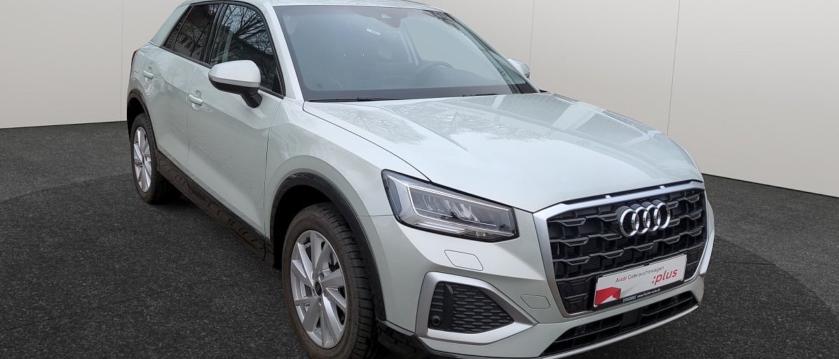 Weißer Audi Q2 SUV in schräger Frontansicht von der Seite