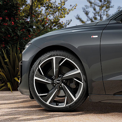 Detailansicht der Seitenpartie des Audi A6 e-tron mit Leichtmetallfelge und S line Emblem