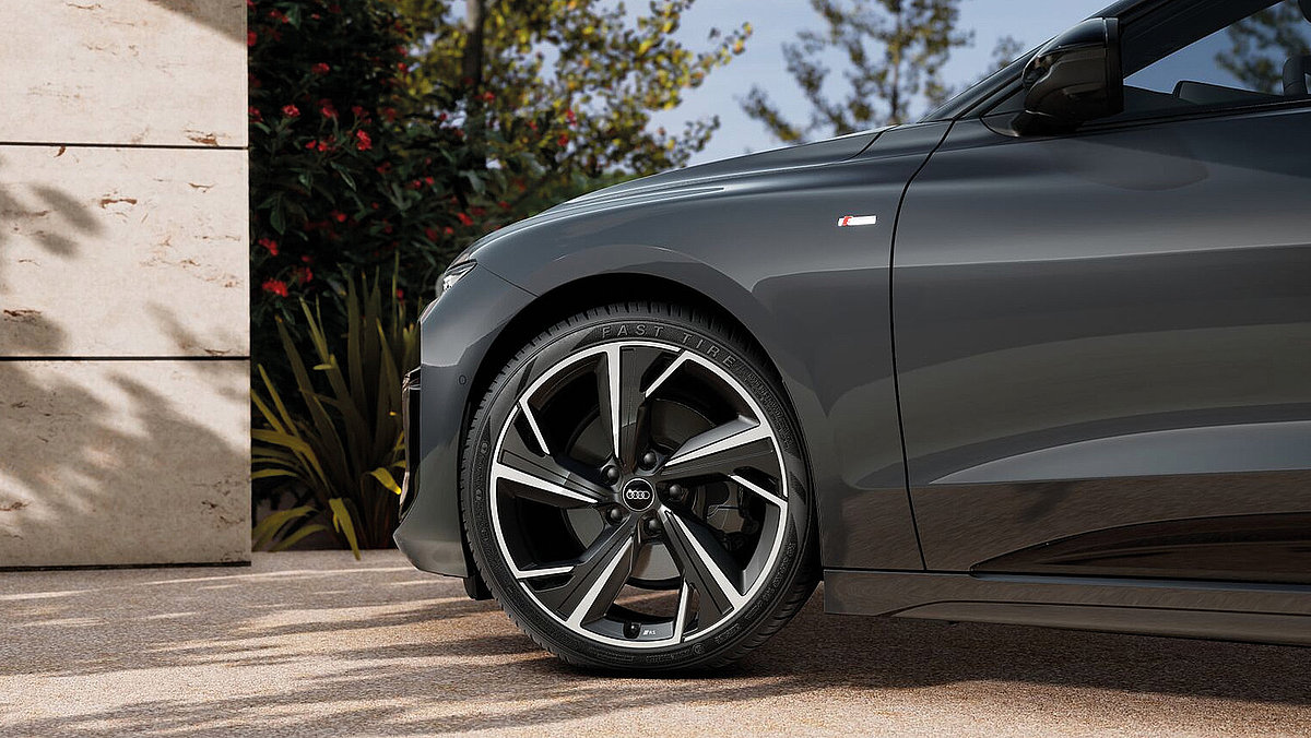 Detailansicht der Seitenpartie des Audi A6 e-tron mit Leichtmetallfelge und S line Emblem