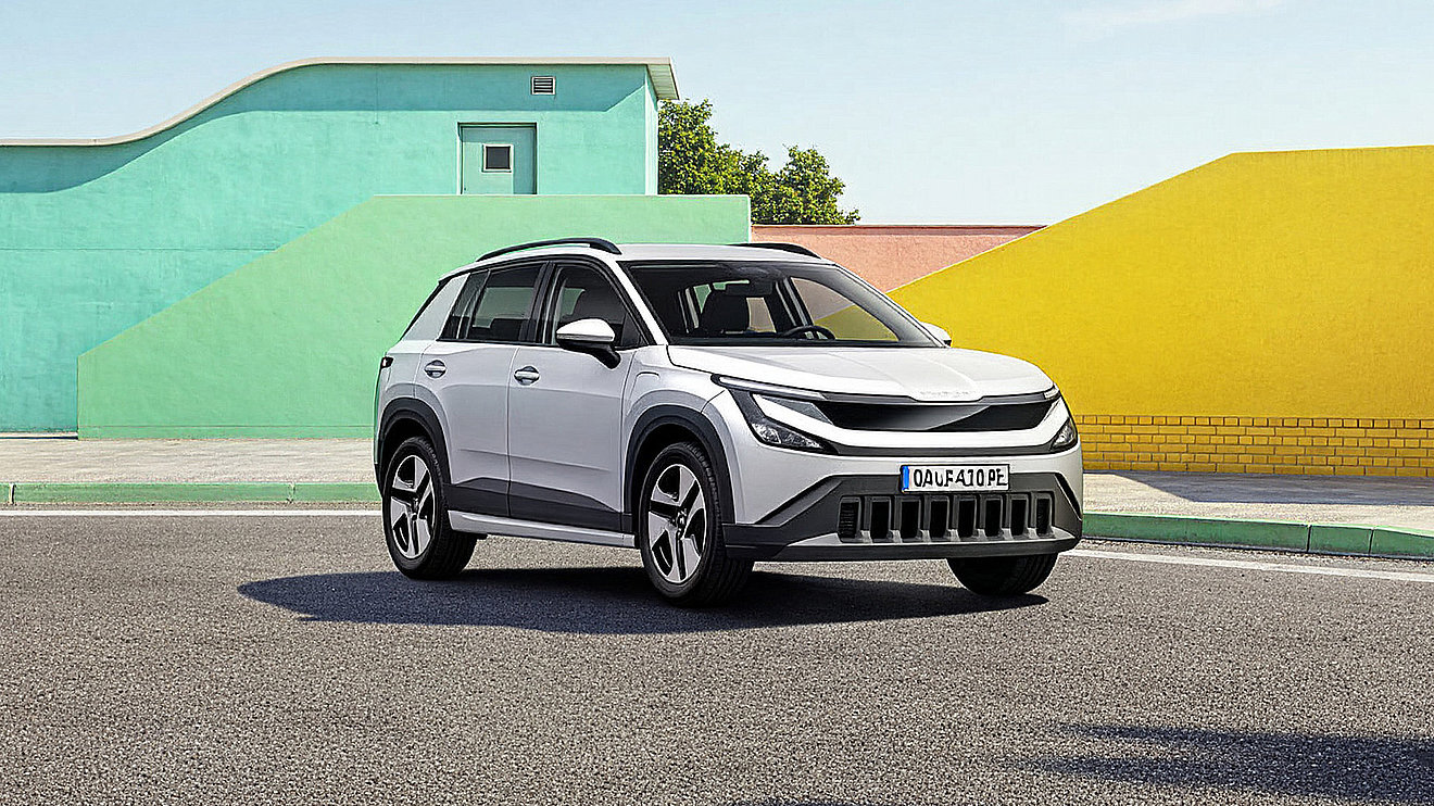 Weißer Škoda Epiq als kompakter Elektro-SUV in Front-Seitenansicht vor farbenfroher Architektur – modernes elektrisches Stadt-SUV mit markantem Design und hoher Alltagstauglichkeit.