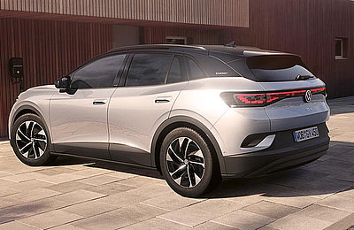 Silberner VW ID.4 Elektro-SUV für Pendler in schräger Heckansicht vor einer modernen Hausfassade