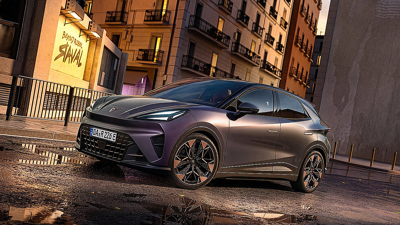 CUPRA Raval als sportlicher Elektro-Kleinwagen in Dunkelgrau, aufgenommen in Front-Seitenansicht auf einer städtischen Straße bei Abendlicht.