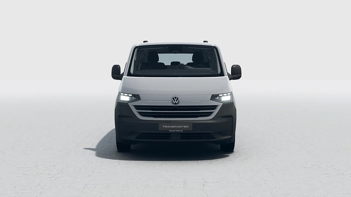 Grauer VW Transporter in der Frontansicht mit eingeschalteten Scheinwerfern auf hellem Untergrund.
